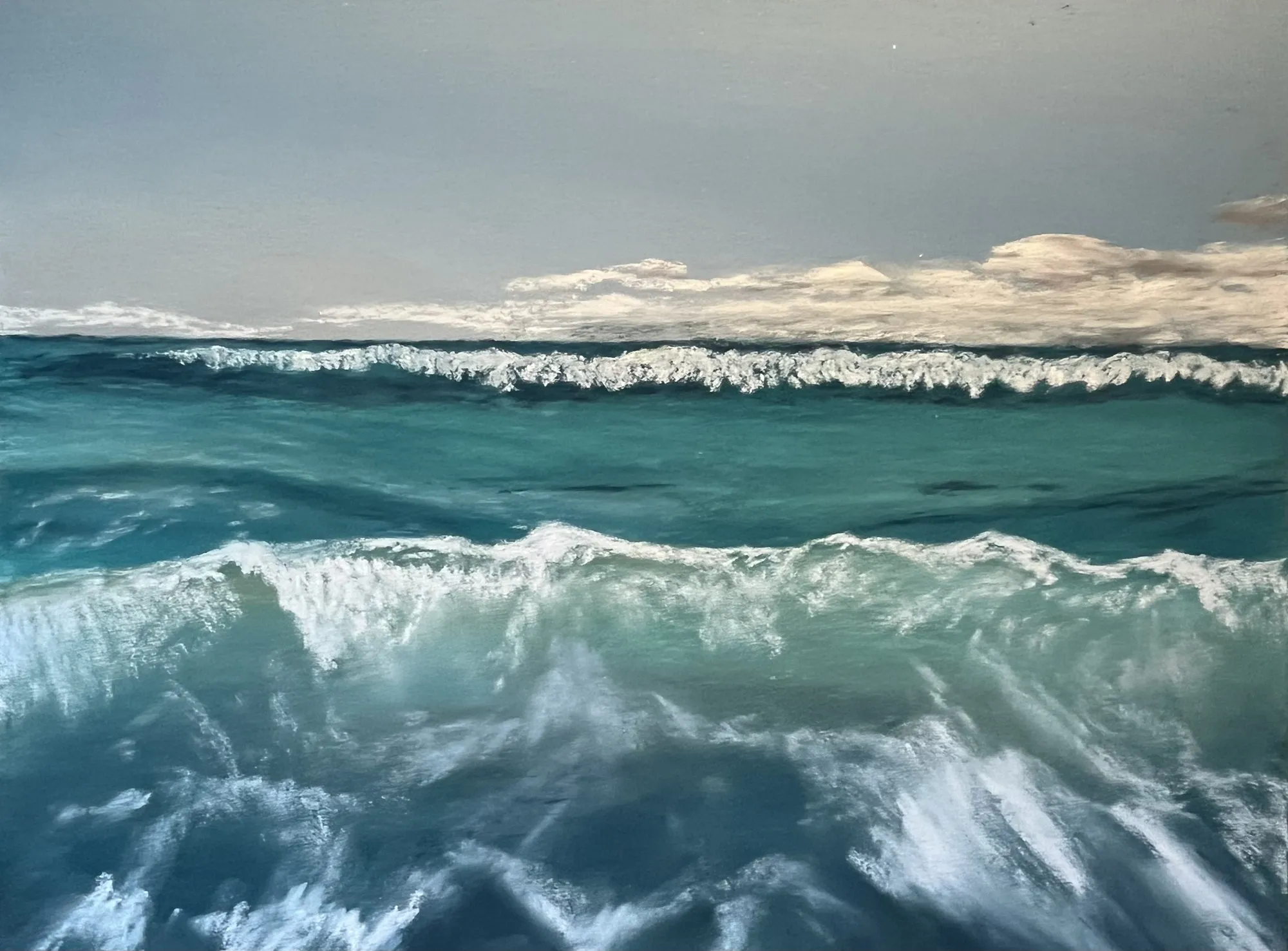 Pastel of a breaking wave seen low and close, with clouds along the horizon.