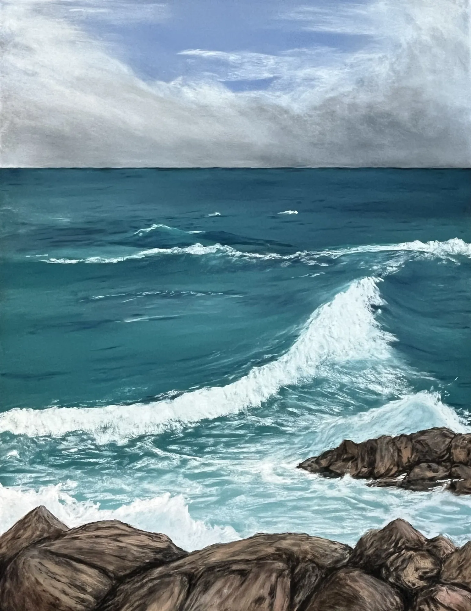 Pastel of turquoise sea breaking over dark rocks in the foreground under a clouded sky.